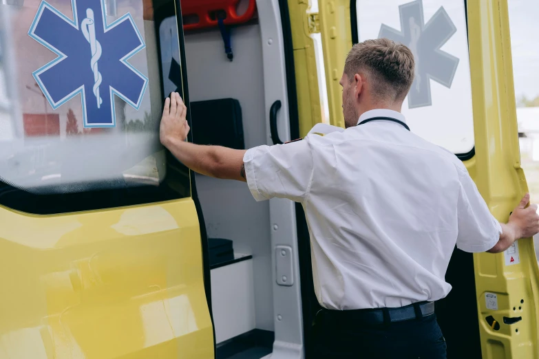 a man is getting out of an ambulance, by Adam Marczyński, pexels, avatar image, yellow and black trim, side profile shot, high resolution image