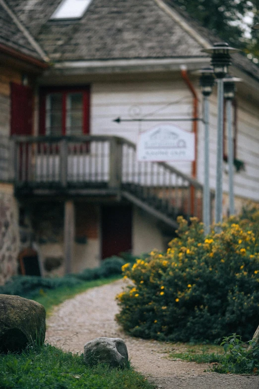 a red fire hydrant sitting on the side of a road, a picture, by Adam Marczyński, unsplash, renaissance, 1 8 8 0 s big german farmhouse, flowers in foreground, small path up to door, tavern