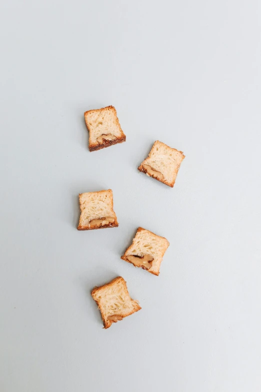 a number of pieces of bread on a white surface, unsplash, minimalism, square shapes, toast, 8 l, dessert