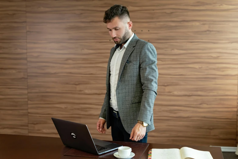 a man standing in front of a laptop computer, pexels, renaissance, business attire, brown, standup, gif