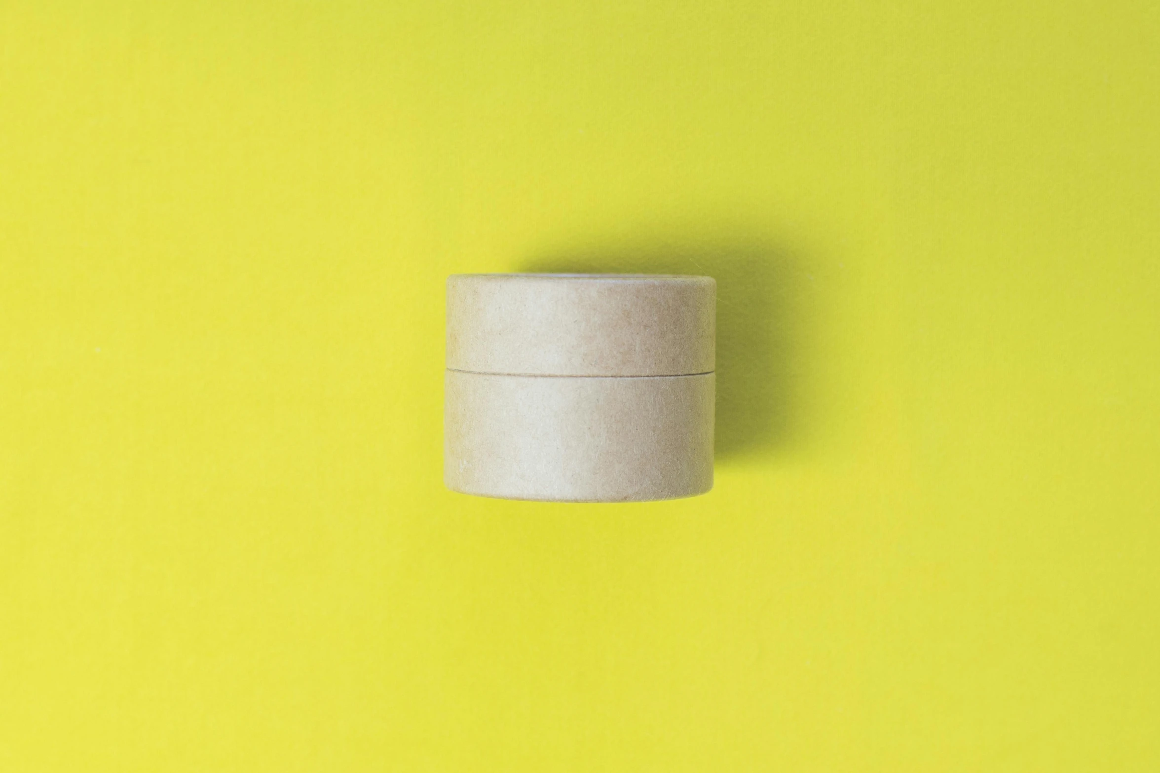 a roll of toilet paper on a yellow background, inspired by Rachel Whiteread, trending on pexels, minimalism, metal lid, white box, vials, circular shape