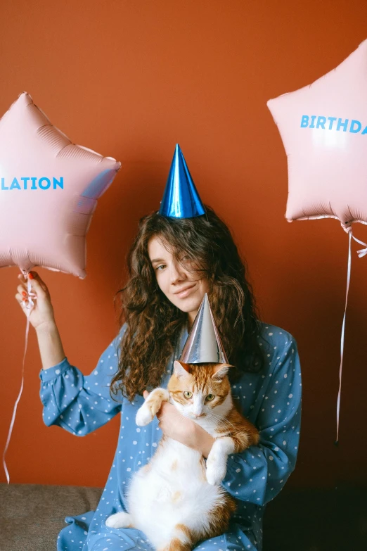 a woman sitting on a couch holding balloons and a cat, trending on unsplash, birthday cake on the ground, brown curly hair, photo booth, on artstastion