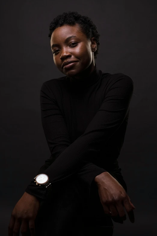 a woman sitting in front of a black background, by Lily Delissa Joseph, pexels contest winner, posing with crossed arms, ( ( dark skin ) ), 15081959 21121991 01012000 4k, wearing a turtleneck and jacket