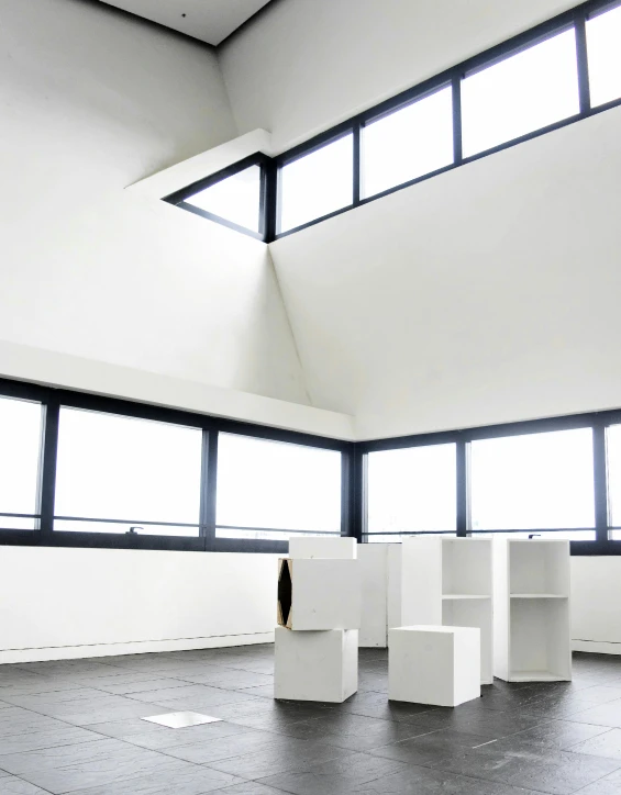 a room with a lot of white cubes in it, inspired by Donald Judd, unsplash, light and space, window view, brutalism style stool, slanted ceiling, three views