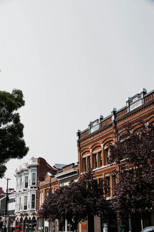 a clock tower sitting on the side of a road, an album cover, unsplash contest winner, vancouver school, victorian buildings, hanging trees, profile image