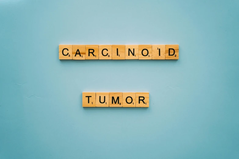 wooden scrabbles spelling the word carcinonoid and tumor on a blue background, by Caro Niederer, trending on unsplash, graffiti, white bg, medical photography, background image, illustration:.4