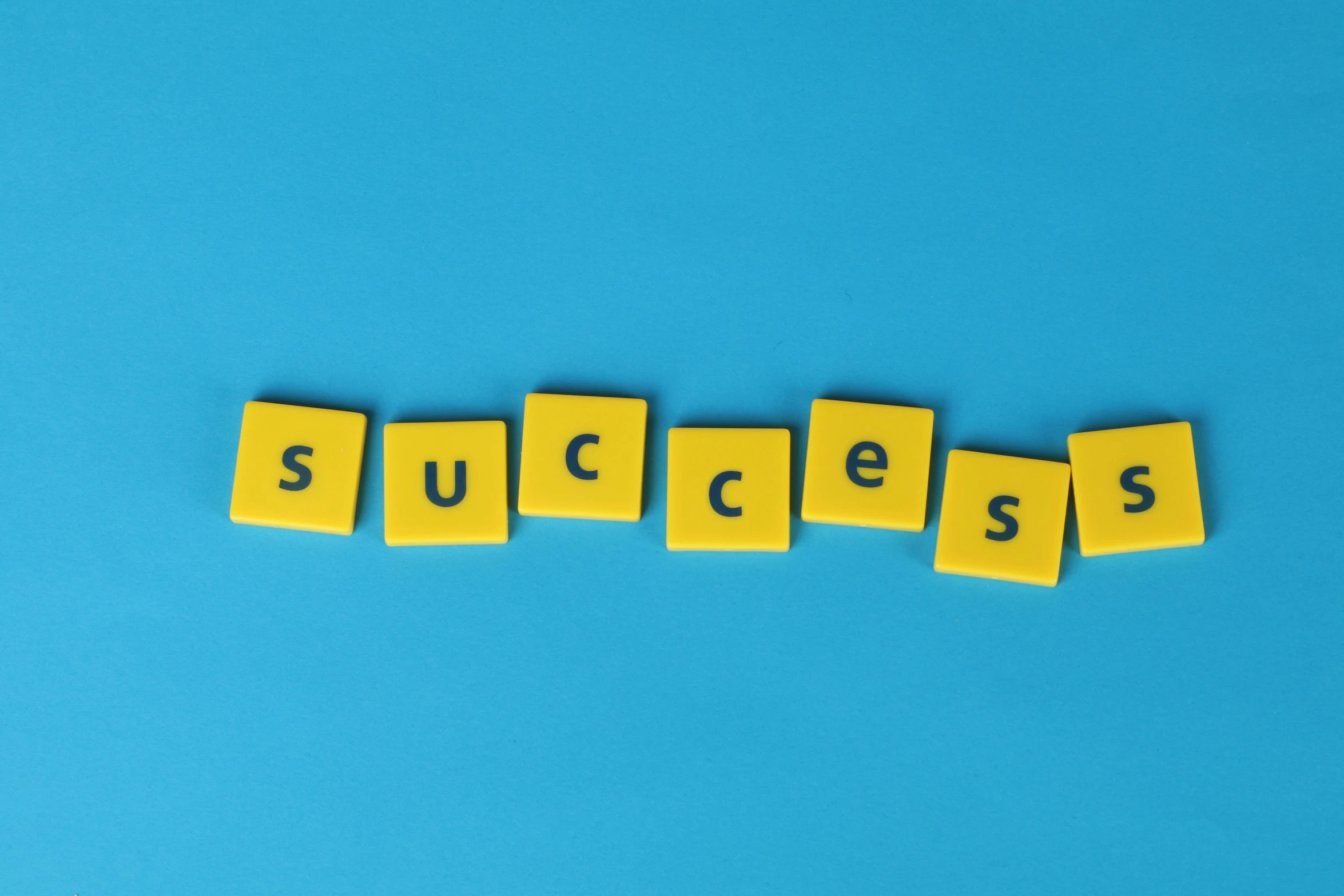 the word success spelled with scrabbles on a blue background, by Daniel Lieske, pexels, on a yellow canva, panels, taken from the high street, avatar image