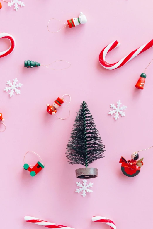 a christmas tree surrounded by candy canes and candy canes, by Julia Pishtar, pink background, flatlay, multiple stories, scientific