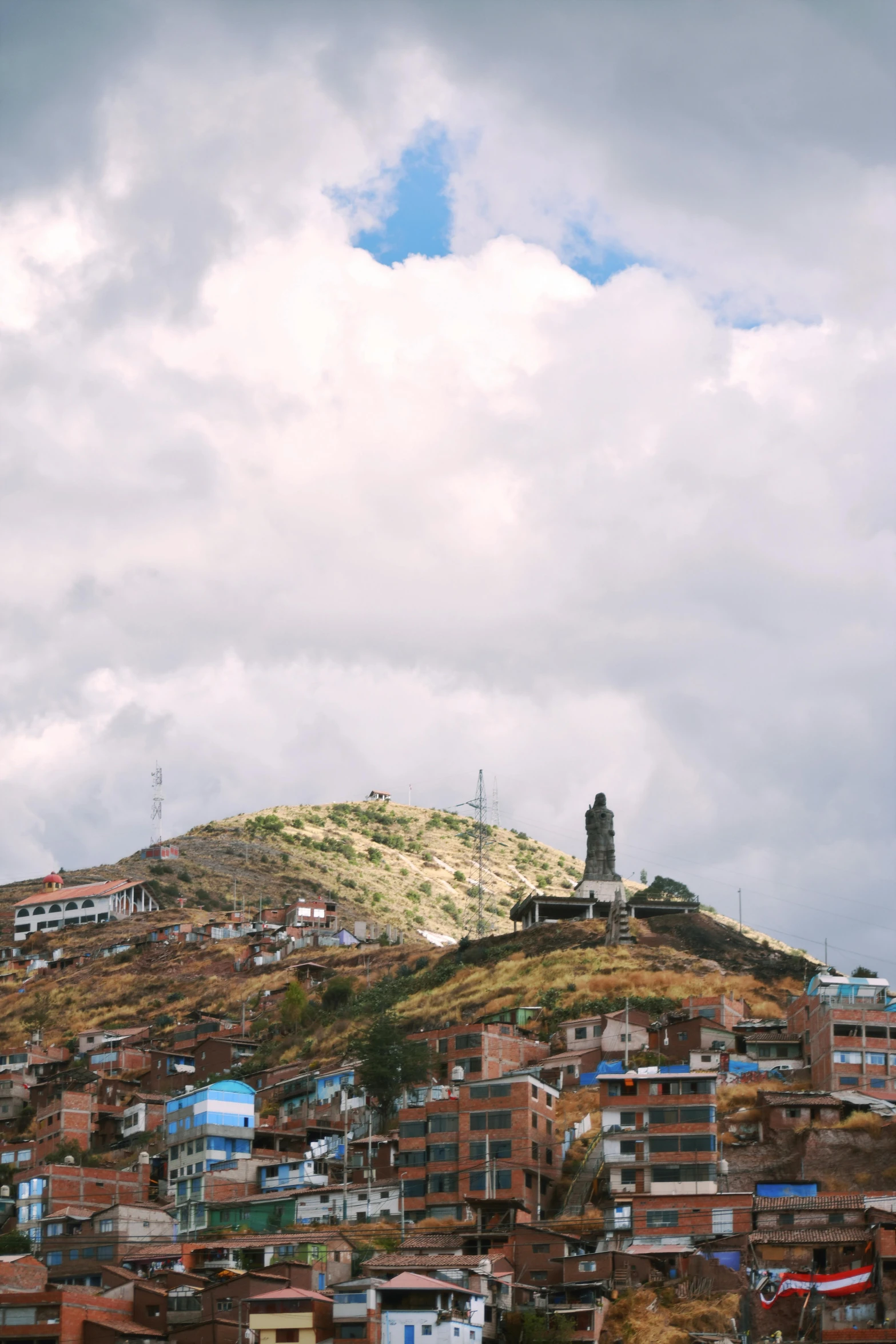 a man flying a kite on top of a lush green hillside, a statue, trending on unsplash, quito school, slum, ivan bolivian, panoramic, square