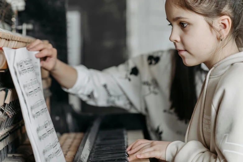 a little girl that is playing a piano, pexels contest winner, looking across the shoulder, nerdy music teacher with phd, thumbnail, high quality photo