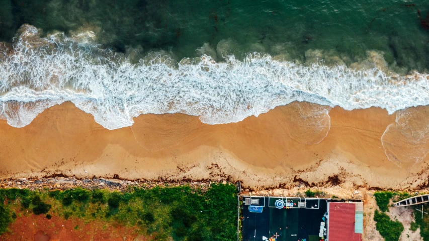 an aerial view of a beach next to the ocean, by Lee Loughridge, pexels contest winner, hurufiyya, icon, brown, vivid and detailed, manly