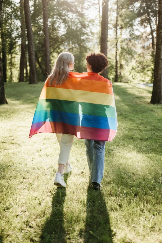 two people walking in a park holding a rainbow blanket, profile image