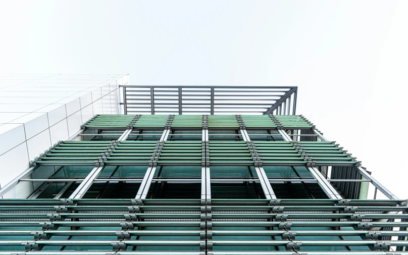 a very tall building with lots of windows, inspired by Andreas Gursky, unsplash, green square, metal panels, low-angle, elevation view