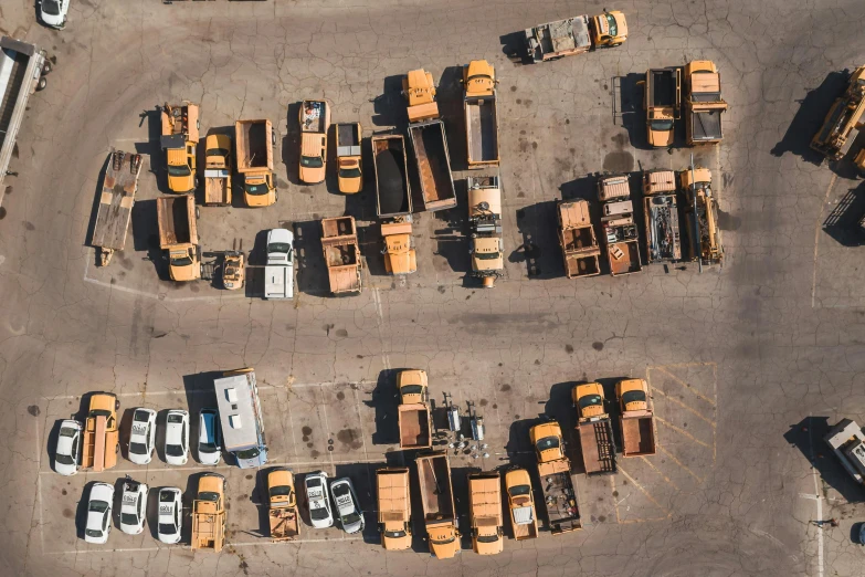 a parking lot filled with lots of yellow trucks, unsplash, auto-destructive art, knolling, post apocalyptic new york, ignant, buses