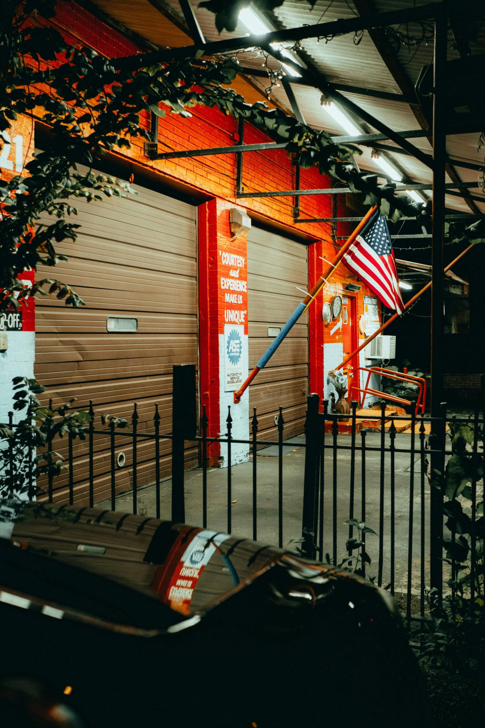 a motorcycle parked in front of a building at night, american flags, car garage, profile image, gritty image