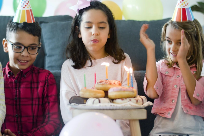 a group of young children sitting on top of a couch, pexels, happy birthday candles, avatar image, snacks, annoyed