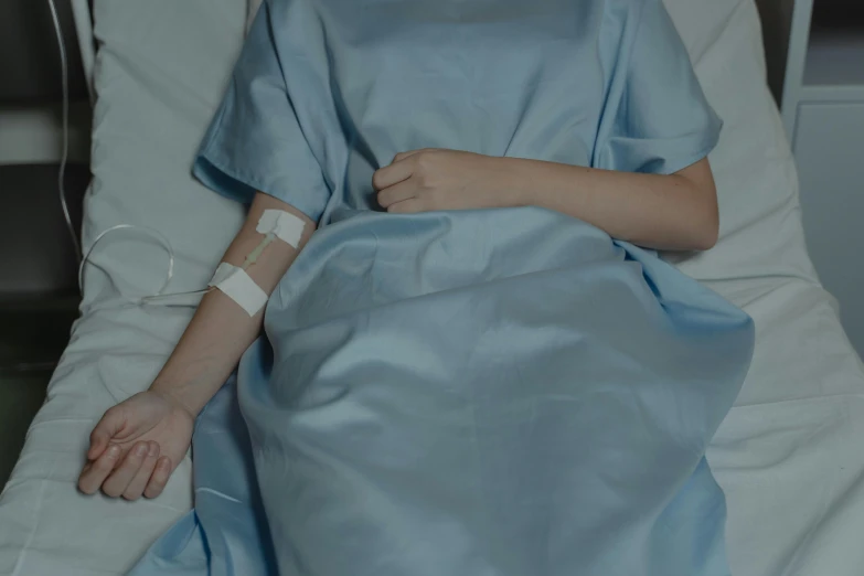 a little girl laying in a hospital bed, trending on pexels, hand on hip, blue, bandage, background image