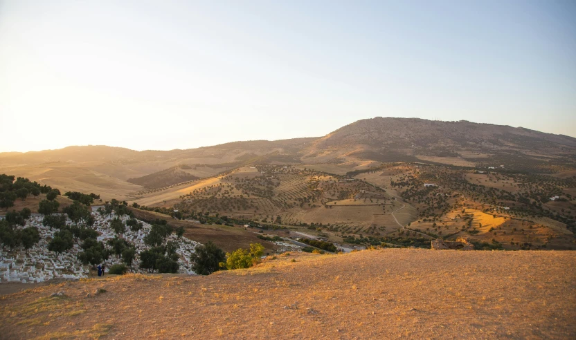 a person riding a skateboard on top of a mountain, les nabis, soil landscape, seen from a distance, golden hour photo, hillside desert pavilion