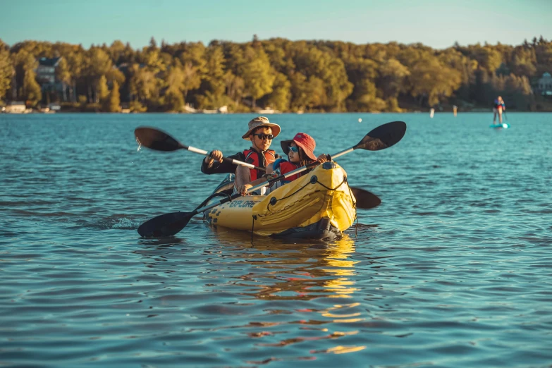 a man riding on the back of a yellow kayak, by Julia Pishtar, unsplash contest winner, sydney park, celebrating, lake blue, inflatable
