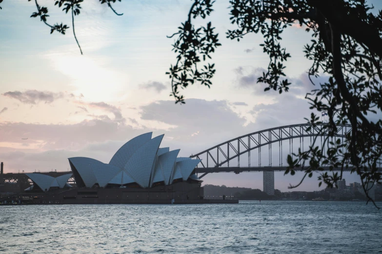 a large body of water with a bridge in the background, inspired by Sydney Carline, pexels contest winner, white sweeping arches, silhouetted, norman foster, an ancient