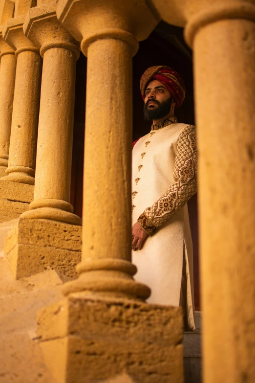 a man in a turban standing in front of a building, pexels contest winner, renaissance, cinematic movie still, stately robes, archways, groom