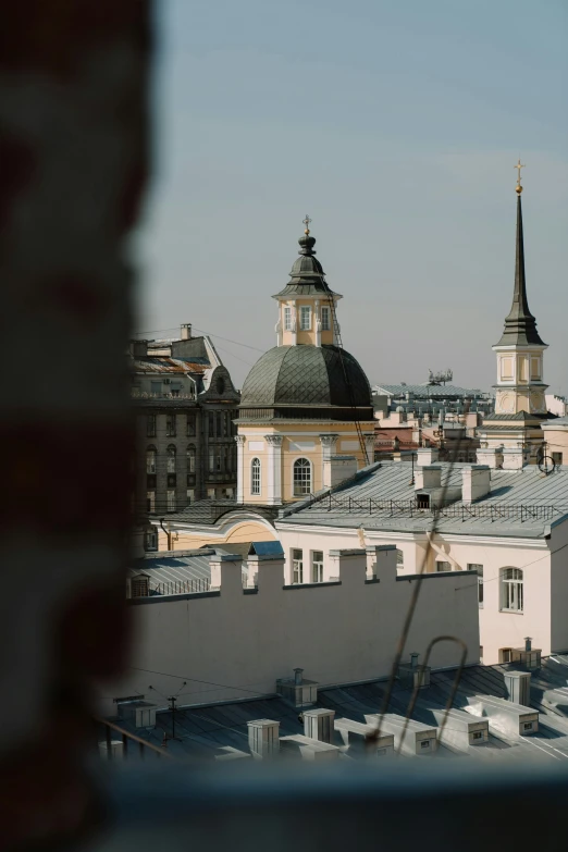a view of a city from a window, inspired by Illarion Pryanishnikov, trending on unsplash, baroque, rounded roof, square, high quality photo, lead - covered spire
