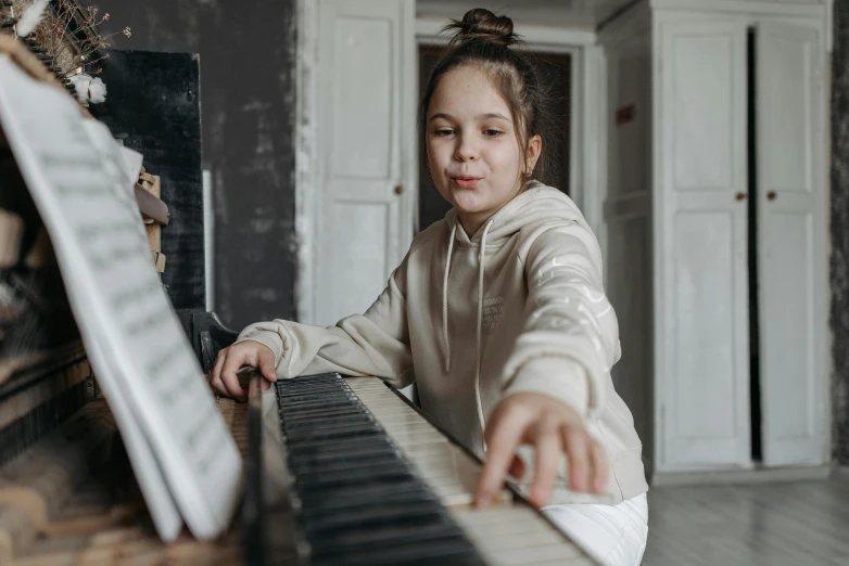 a little girl sitting in front of a piano, pexels contest winner, danube school, avatar image, girl wearing hoodie, thumbnail, abcdefghijklmnopqrstuvwxyz