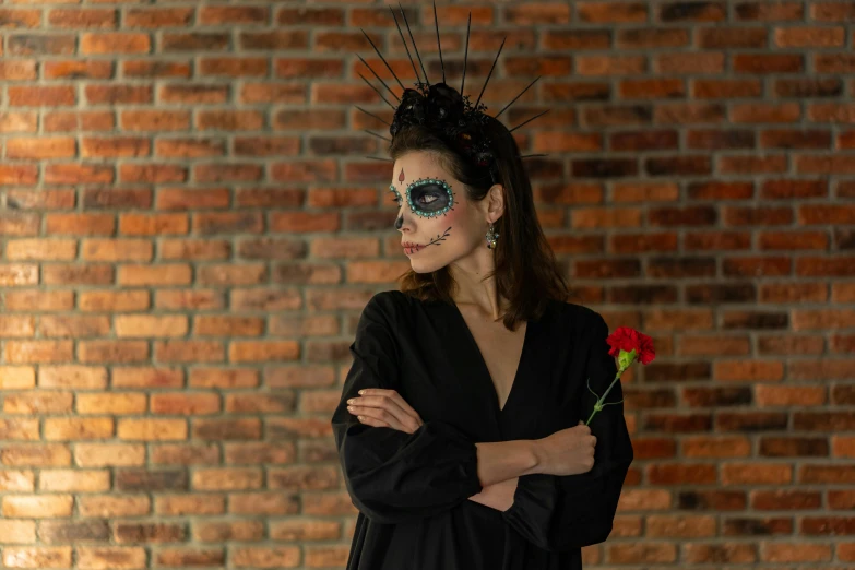 a woman standing in front of a brick wall, a portrait, pexels contest winner, antipodeans, day of all the dead, black rose, costume desig, background image