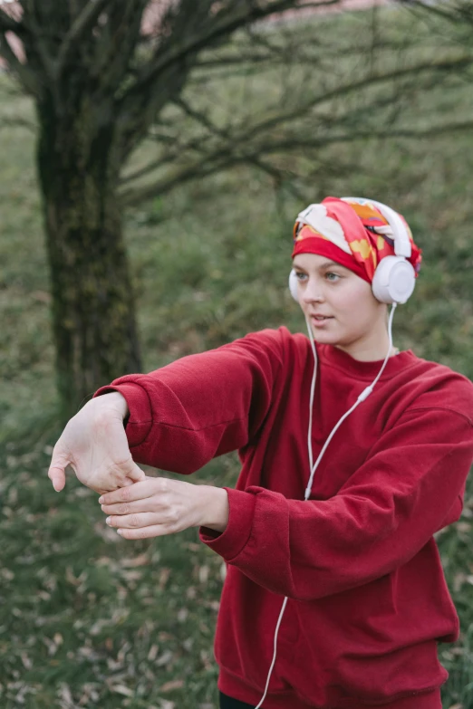 a young man wearing headphones and listening to music, by Anna Füssli, unsplash, renaissance, wearing a head scarf, tai chi, red sweatband, arms extended