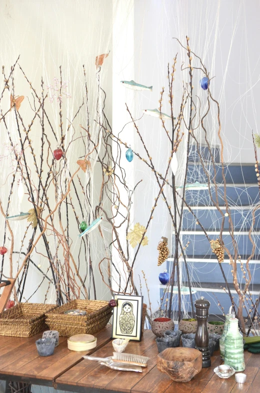 a table that has a bunch of branches on it, an album cover, arts and crafts movement, easter, sculpture on display, birds on cherry tree, healing pods