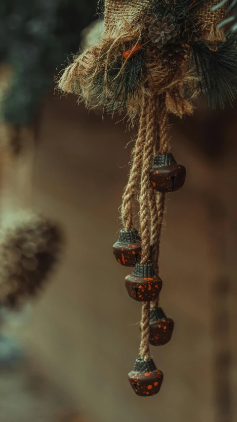 a close up of a stuffed animal hanging from a rope, a macro photograph, by Elsa Bleda, trending on pexels, arts and crafts movement, oak acorns, beautiful moorish ornament, high quality photo, brown