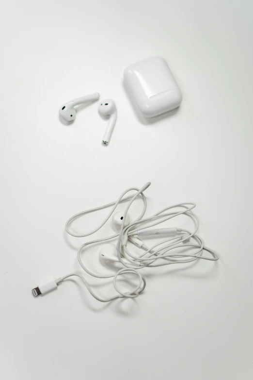 an apple airpods sitting on top of a white table, by Gavin Hamilton, cables out of the ears, ( ( photograph ) ), pitt, v 8 k