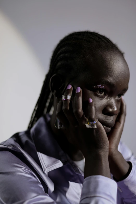 a close up of a person talking on a cell phone, afrofuturism, adut akech, painted nails, looking sad, photographed for reuters