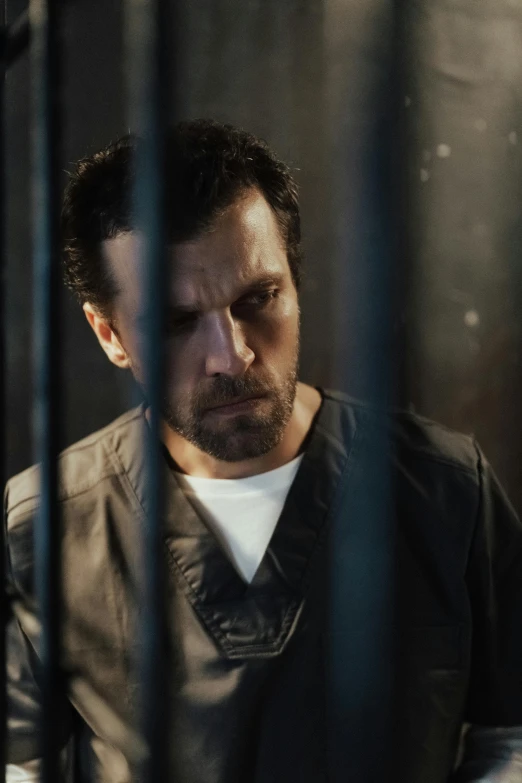 a man is sitting in a jail cell, inspired by John Noble Barlow, henry cavill, dynamic closeup, imdb, upset