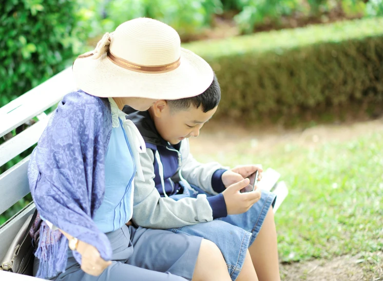 a couple of people that are sitting on a bench, phone wearing a cowboy hat, kids playing, li zixin, reading