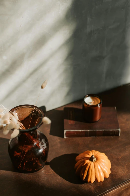 a wooden table topped with a vase filled with flowers, a still life, trending on unsplash, pumpkin, dwell, brown, set photo