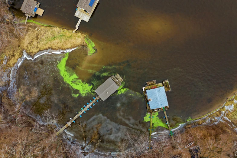 a group of boats sitting on top of a body of water, by Arnie Swekel, pexels contest winner, environmental art, green gas spreading across land, acryllic spill, settlement, il