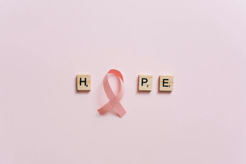 a pink ribbon with the word hope spelled on it, pexels, happening, instagram post, ad image, - 12p, honey