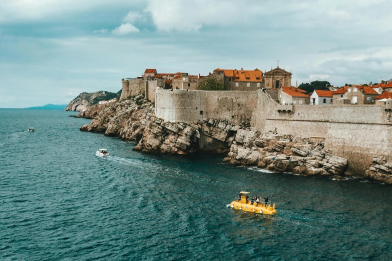 a yellow boat in the middle of a body of water, by Emma Andijewska, pexels contest winner, renaissance, croatian coastline, city walls, slide show, thumbnail