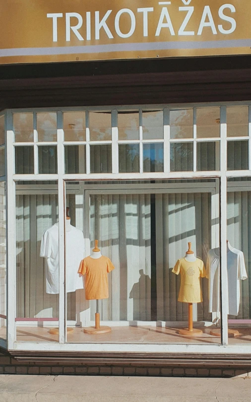 a store front with three mannequins in the window, by Pamela Ascherson, pexels, dressed in a white t-shirt, orange and white color scheme, front view 1 9 9 0, home display