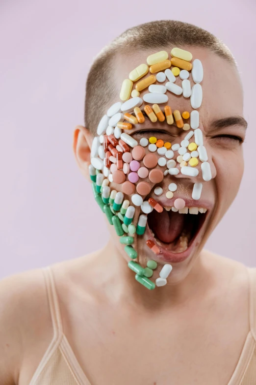 a woman with a lot of pills on her face, inspired by Damien Hirst, trending on pexels, antipodeans, head bent back in laughter, emaciated shaved face, lesbians, totally radical