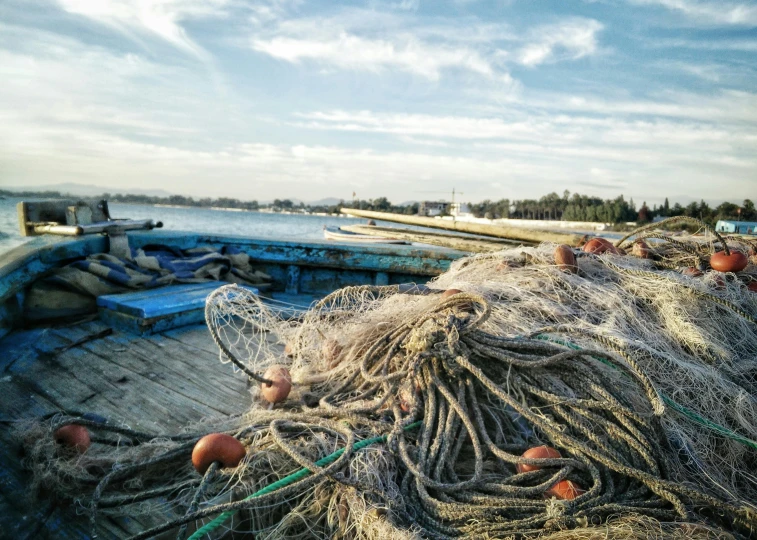 a pile of fishing nets sitting on top of a boat, pexels contest winner, next to the sea, instagram post, harbor, high resolution photo