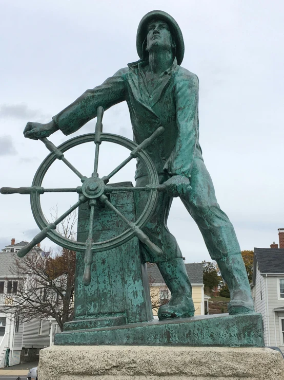 a statue of a man holding a steering wheel, upon a peak in darien, on the bow, aggressive pose, 🚿🗝📝