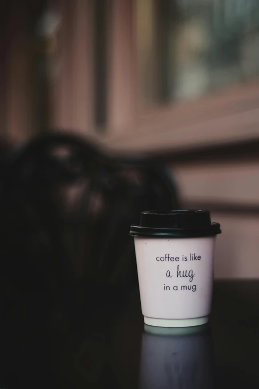 a coffee cup sitting on top of a table, pexels contest winner, sweet hugs, promo image, paper cup, black