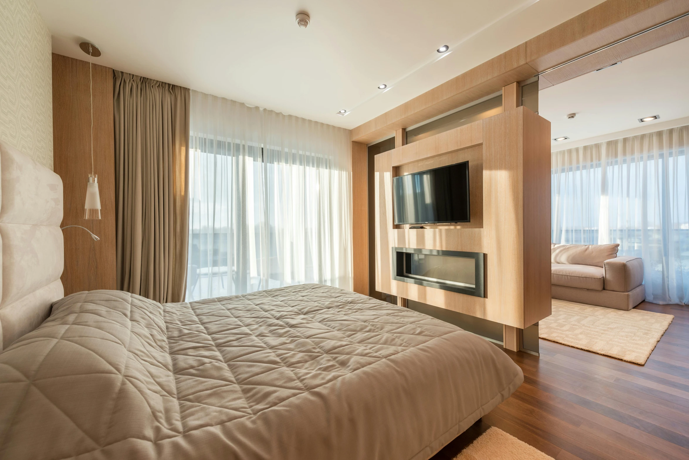 a bed room with a neatly made bed and a flat screen tv, by Alexander Fedosav, unsplash, beige and gold tones, penthouse, wooden floors, platinum