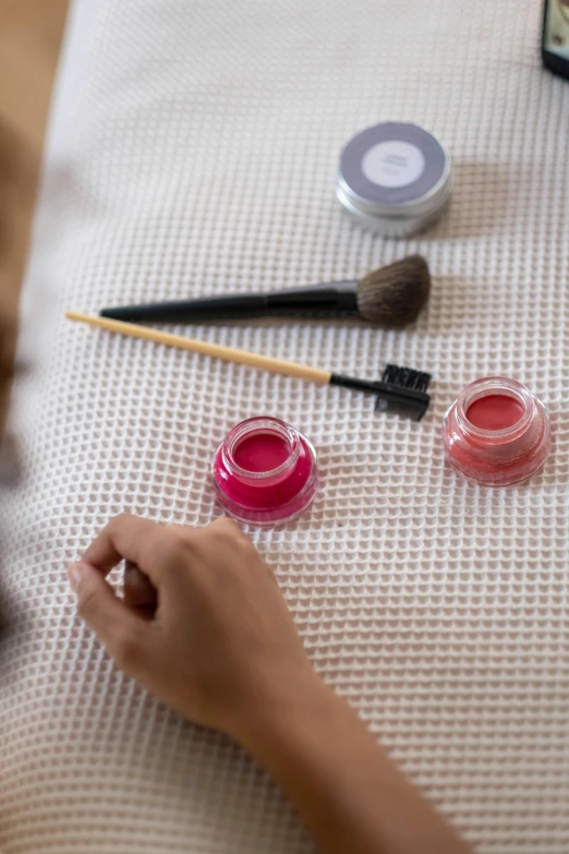 a close up of a person sitting on a bed, putting on lipgloss, hammershøi, synthetic bio skin, brush paint