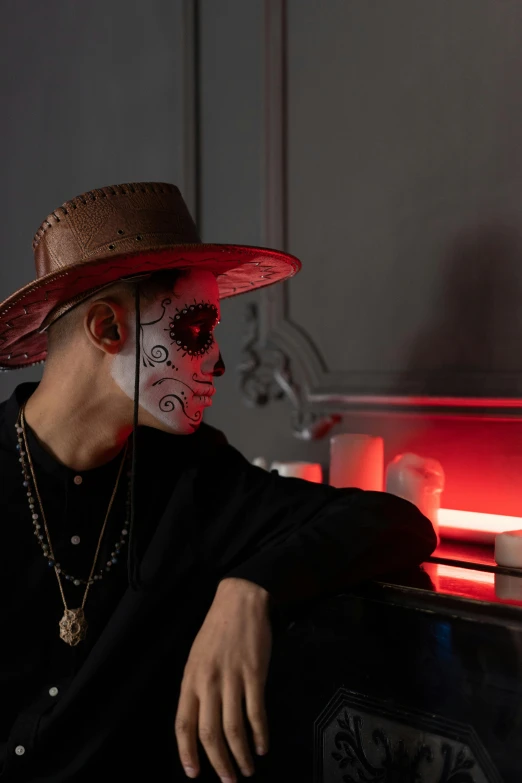 a man sitting on top of a couch wearing a hat, an album cover, inspired by Hedi Xandt, pexels contest winner, vanitas, dia de los muertos makeup, day - glow facepaint, asian man, profile image