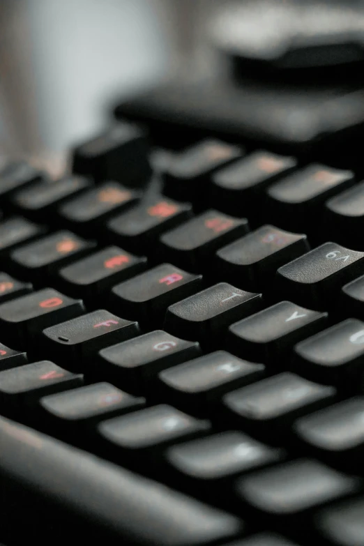 a computer keyboard sitting on top of a desk, dark grey and orange colours, multiple stories, up close image, stacked image