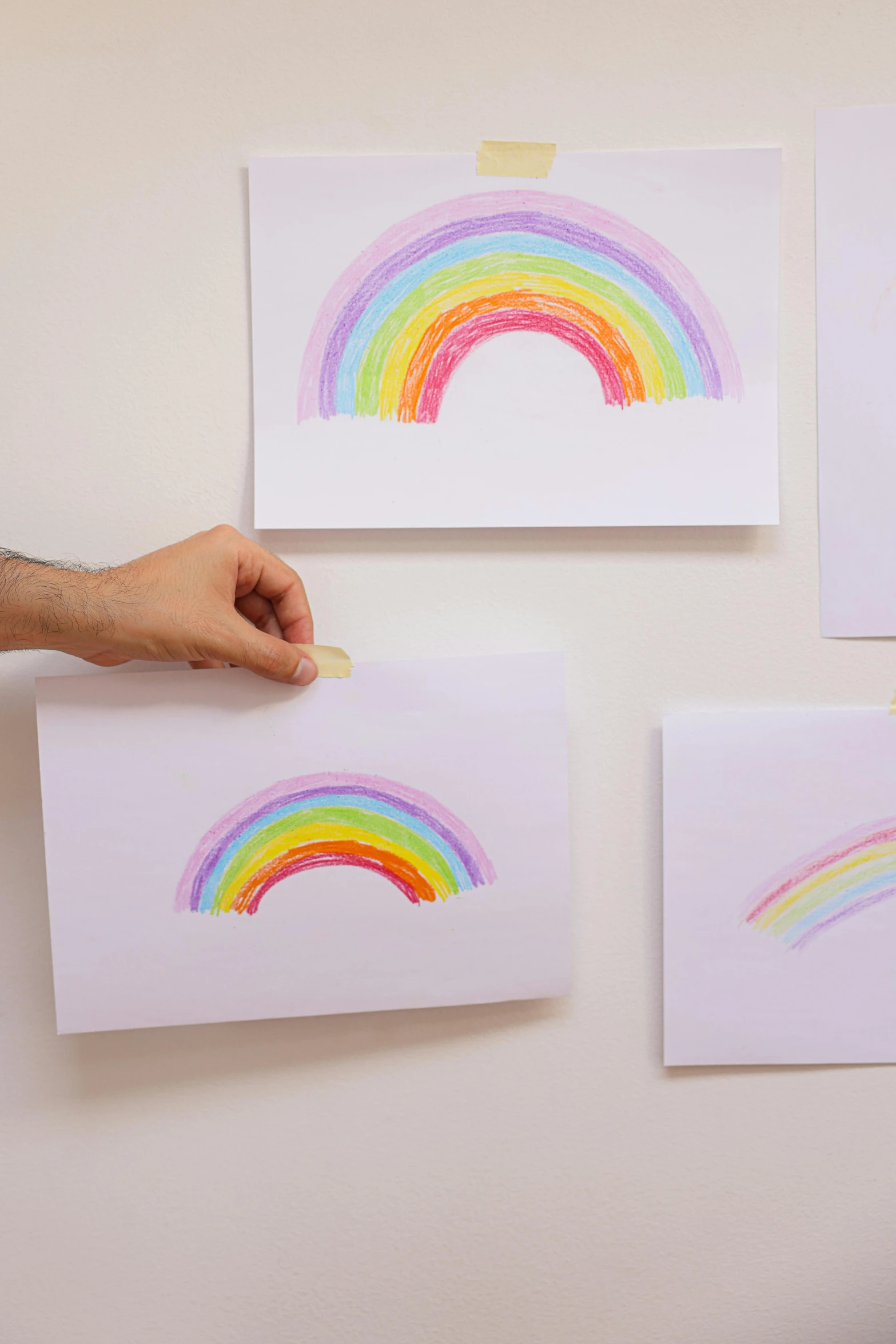 a person holding a piece of paper with a rainbow drawn on it, a child's drawing, by Rachel Reckitt, stickers, wall art, thumbprint, detail shot