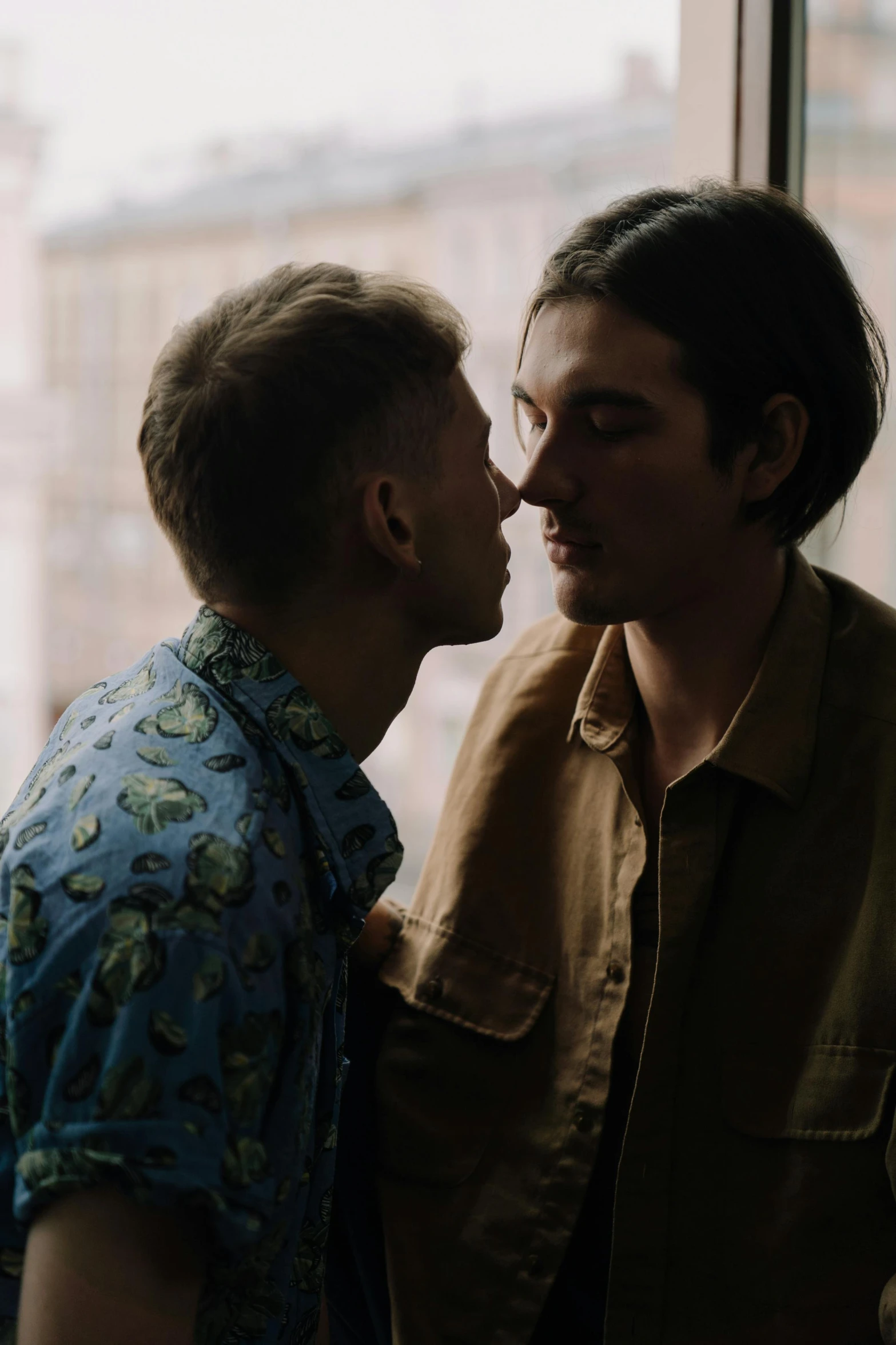 a couple of men standing next to each other, kissing, still from a music video, non binary model, romantic lead